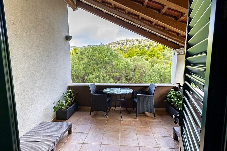 Covered terrace with wooden ceiling and garden furniture