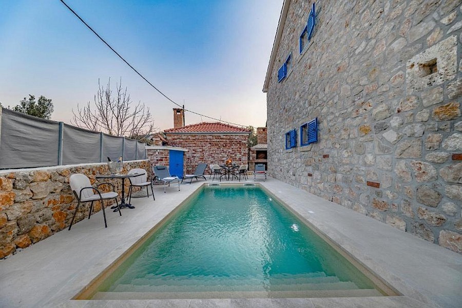 Swimming pool in front of the natural stone facade