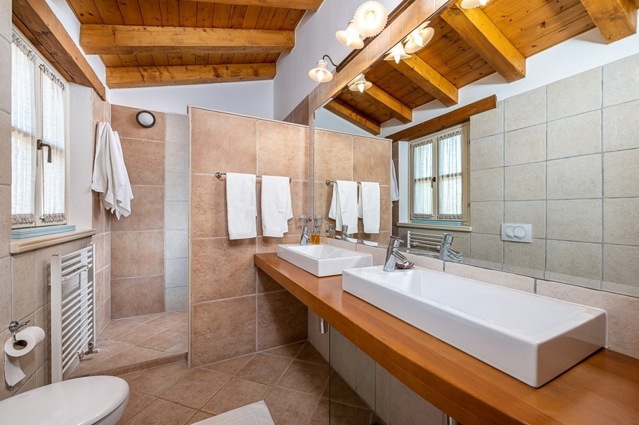 Bathroom with two washbasins and wooden shelf