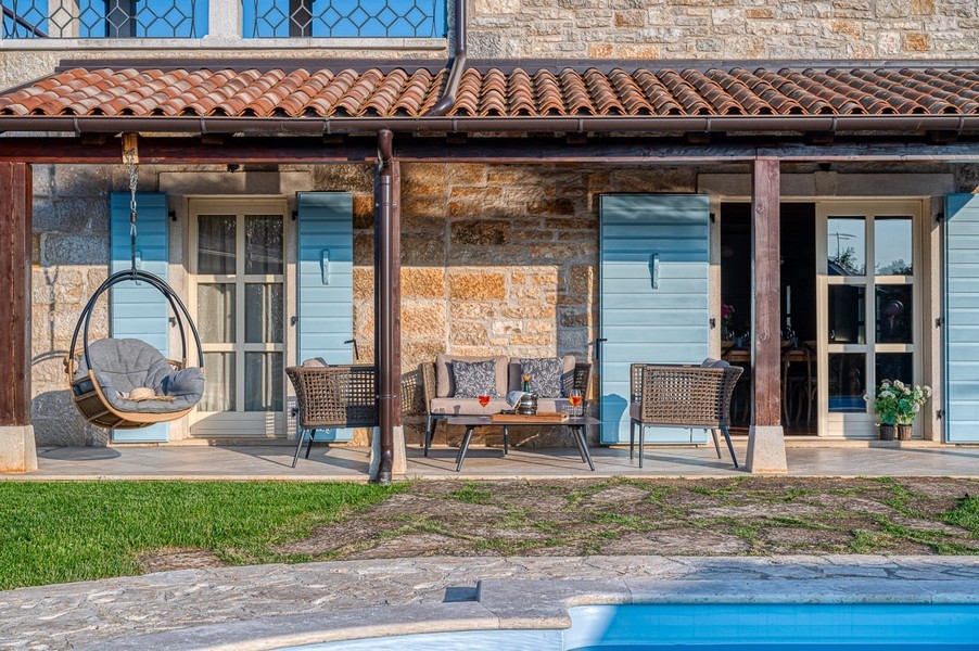 Seating area under the terrace roof beside the pool
