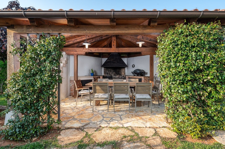 Covered outdoor kitchen with grill and dining table