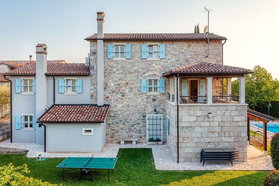 Side view of the stone house with lawn and chimneys