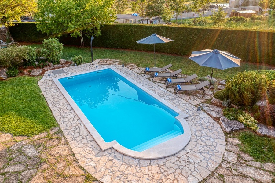 Pool with sun loungers, parasols and lawn
