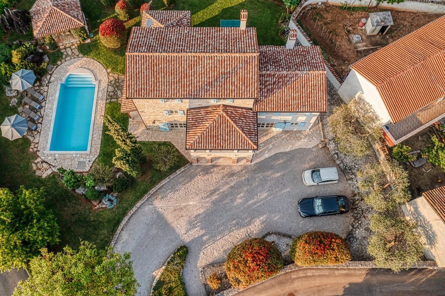 Aerial view of house, pool and driveway with two cars