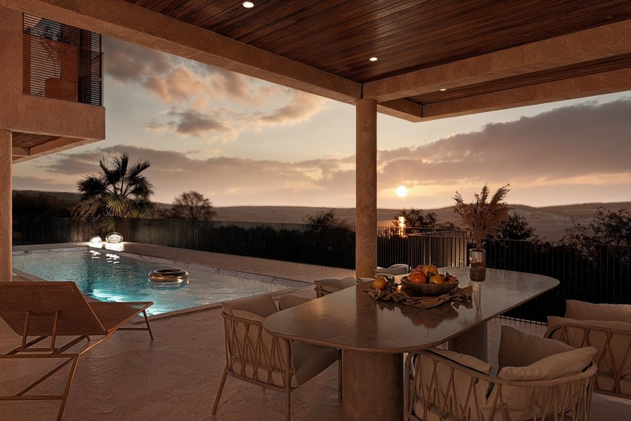 Covered terrace with pool at sunset