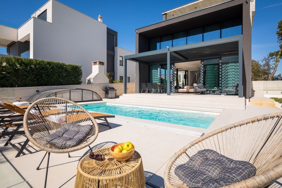 Pool area with hanging chairs and barbecue