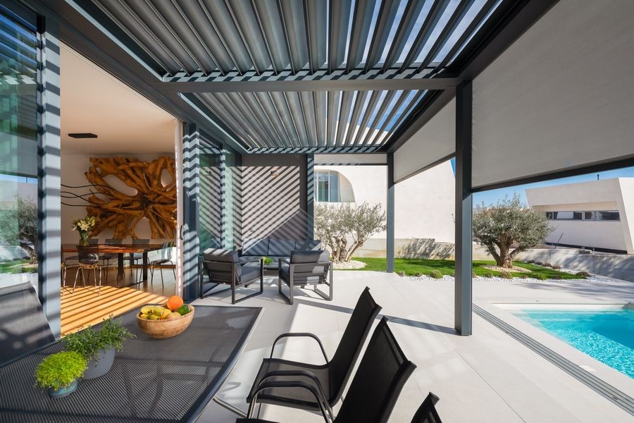 Covered terrace with dining table by the pool