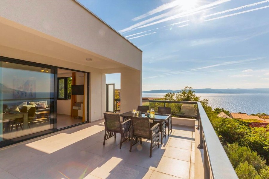 Terrace with dining table and view of the sea