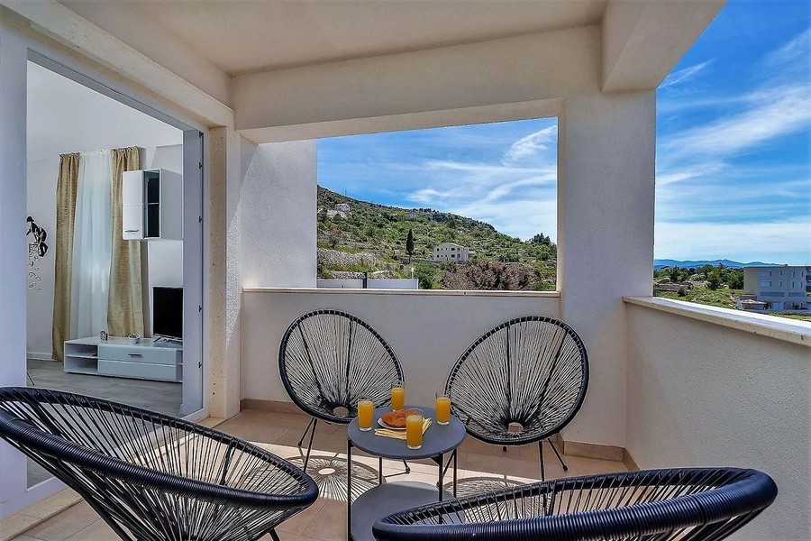 Terrace with wicker chairs and view of the coast