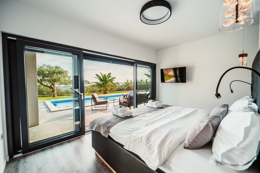 Bedroom with glass front facing the pool