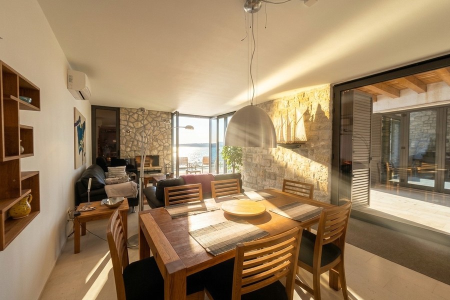 Dining table in front of glass front facing the sea