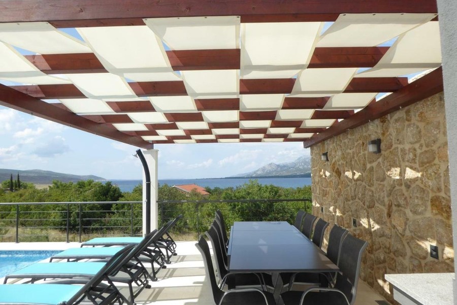 Covered terrace with dining table and sea view