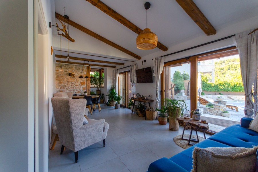 Living room with wooden beams and glass door to the courtyard