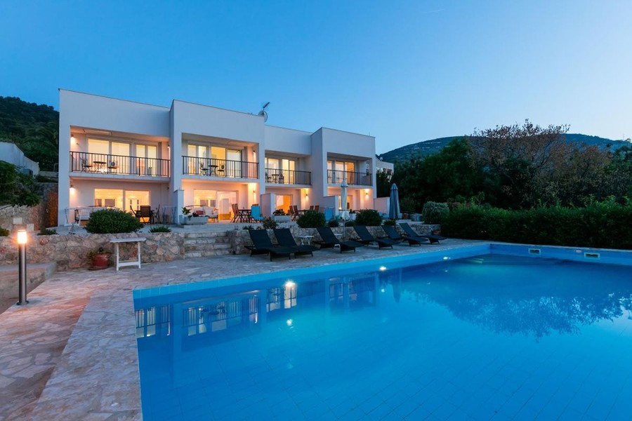 Apartment building with illuminated pool in the evening