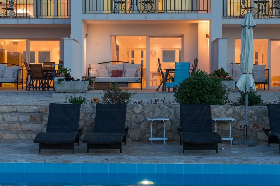 Terraces of the residential units with sun loungers by the pool