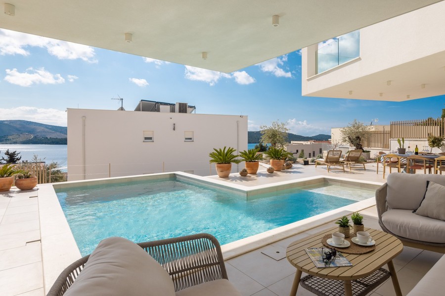Covered terrace with view of the pool and sea