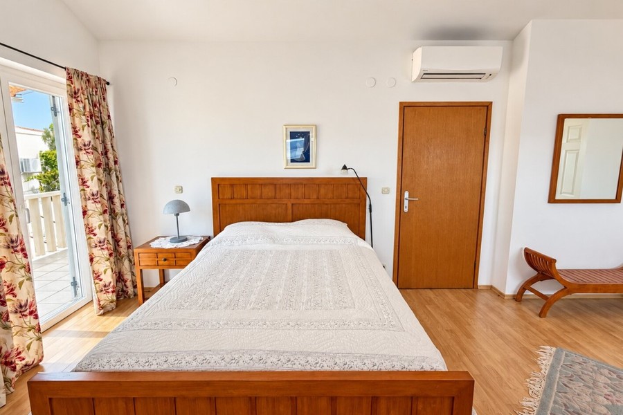 Bedroom with wooden bed and air conditioning