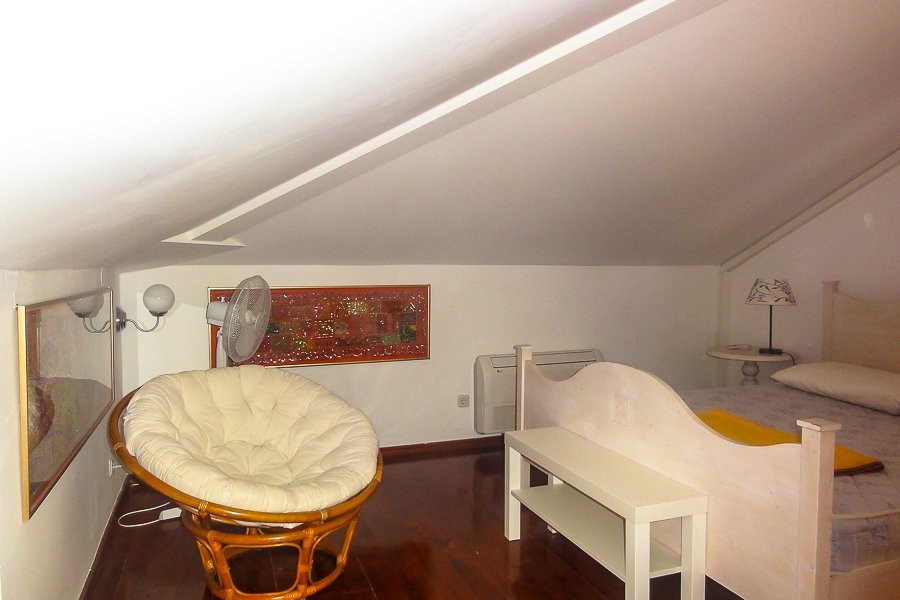 Attic room with bed and armchair