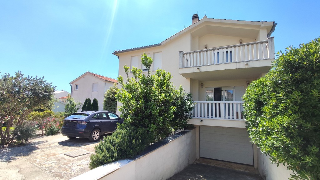 House front with balcony and garage driveway