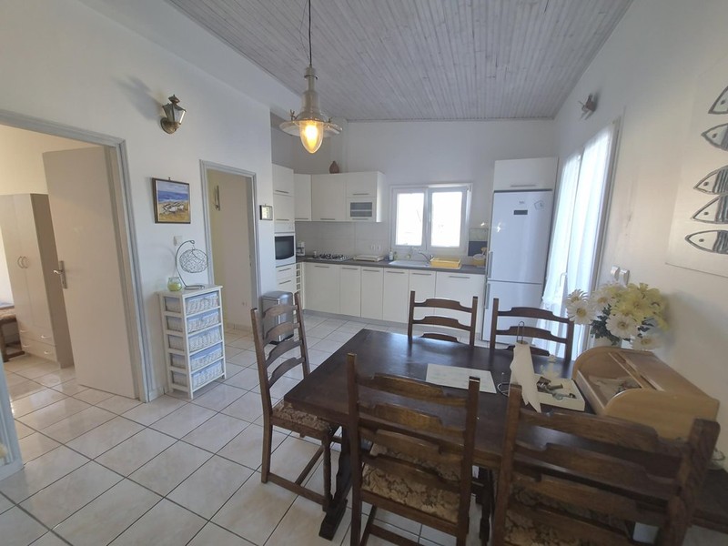 Dining area with wooden table in front of the kitchen
