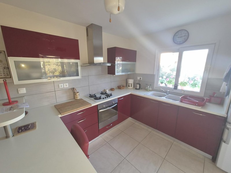 Kitchen with red cabinet fronts and window