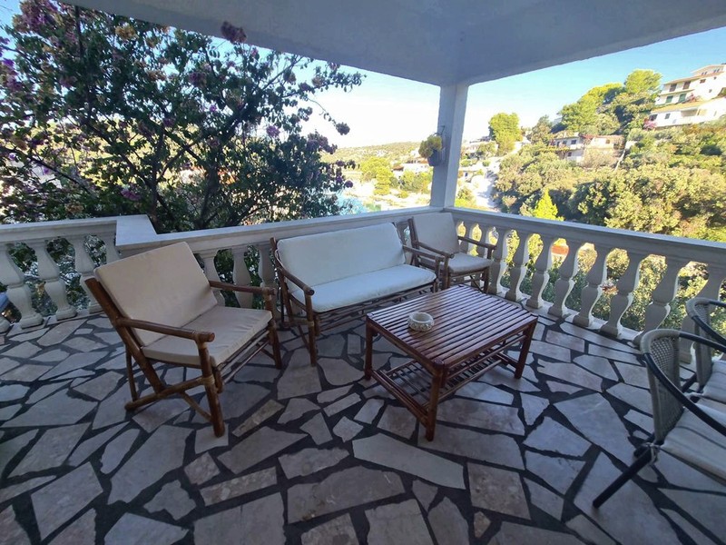 Covered terrace with seating area and sea view