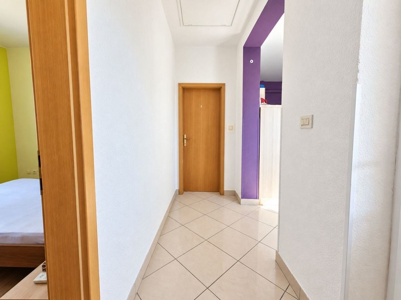 Hallway with tiled floor and room doors